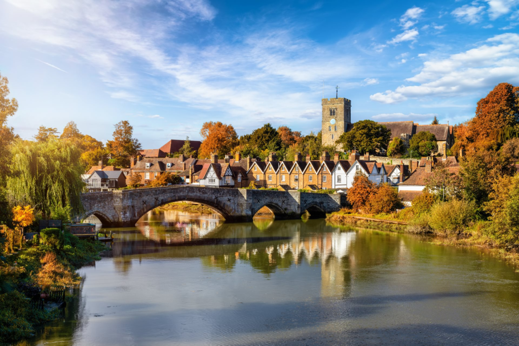 a bridge over a river with houses and trees in the background life in autumn